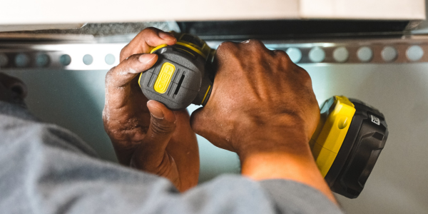 A close up of a yellow power drill being used.